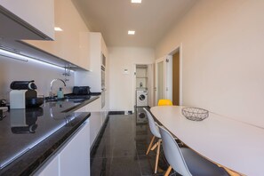Eine moderne Küche mit Essbereich, ausgestattet mit Backofen, Spüle und Waschmaschine.