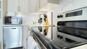 Een moderne keuken met roestvrijstalen apparatuur, een vaatwasser en een magnetron.