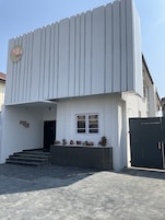 A modern building with a sign reading "Ring Ruby Hotel" and a staircase leading to the entrance.