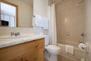 Een haardroger, handdoeken, zeep, toiletpapier