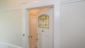 Uma porta branca com vitrais e o número '44' em destaque acima.