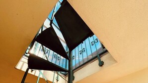 Eine Wendeltreppe mit Metallgeländer und Oberlicht darüber.