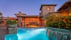 A pool area with a waterfall feature, stone architecture, and outdoor seating. - 3BR Luxury Villa @ The Rocks, Pool,Troon Golf, Spa, Daily Cleaning, Clubhouse (Scottsdale)