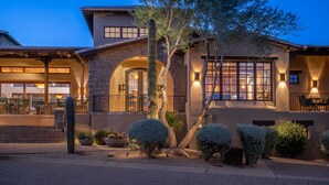 A multi-story house with a stone facade, arched windows, and a patio area with outdoor seating. - 3BR Luxury Villa @ The Rocks, Pool,Troon Golf, Spa, Daily Cleaning, Clubhouse (Scottsdale)