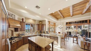 A spacious kitchen with wooden cabinets, a large island, and a dining area with a view. - 3BR Luxury Villa @ The Rocks, Pool,Troon Golf, Spa, Daily Cleaning, Clubhouse (Scottsdale)