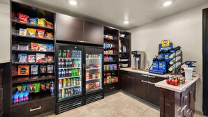 Ein gut sortierter Kiosk mit Regalen voller Snacks, Getränke und einer Kaffeestation.