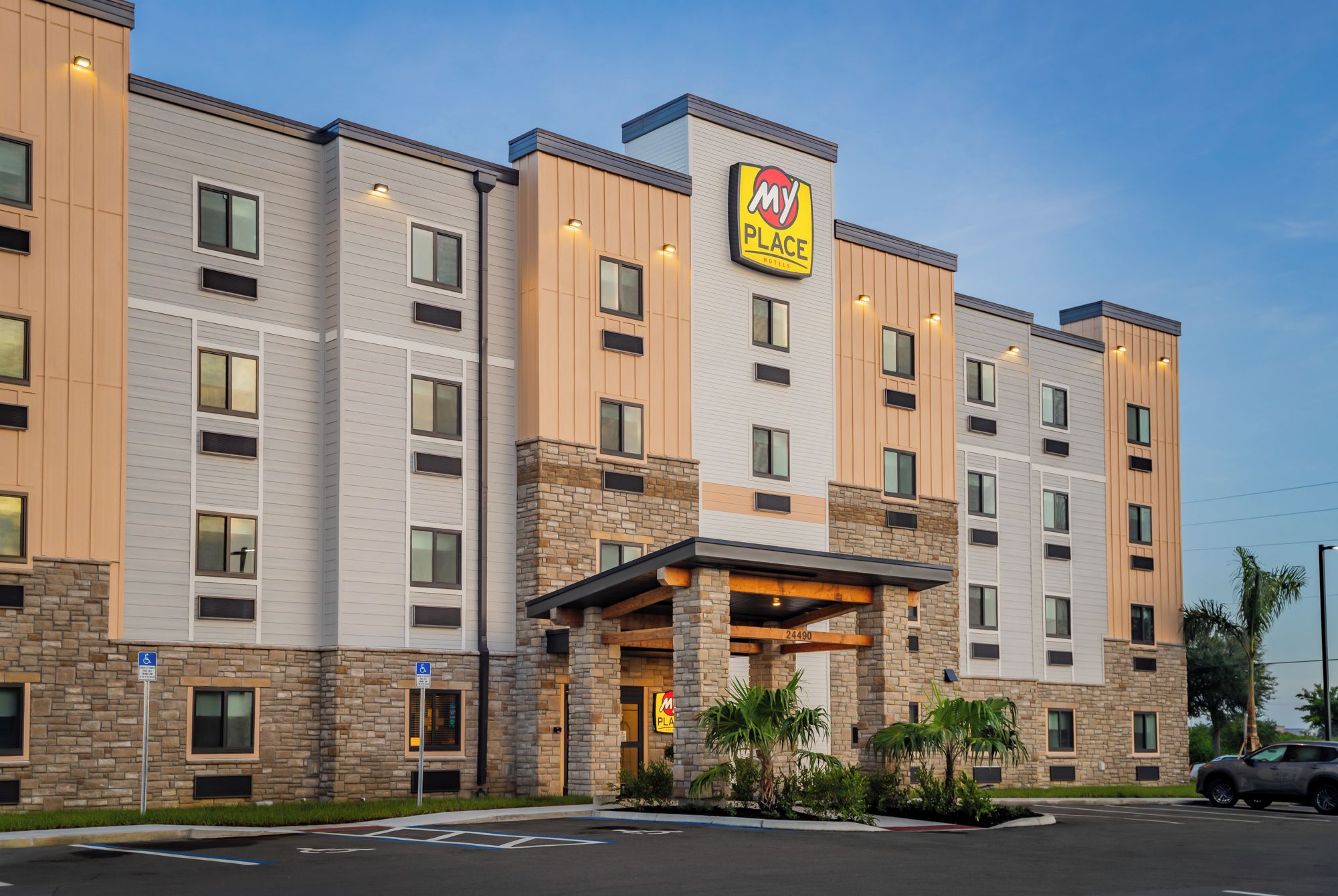 A multi-story hotel with a prominent 'My Place Hotels' sign, a covered entrance, and a parking lot.