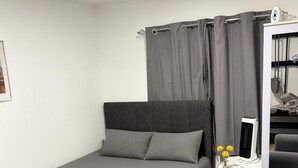 Une chambre à coucher moderne avec un lit, une table de chevet avec une lampe, une chaise et une armoire.