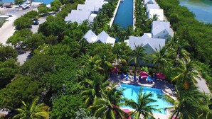 An aerial view of a resort with a central swimming pool surrounded by palm trees and resort buildings. - Gorgeous Coral Lagoon Villa - Top Rated Resort in Marathon w/ Boat Slip -Amazing (Marathon)