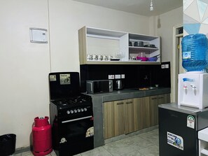 A compact kitchen with a gas stove, a microwave, a kettle, and a water dispenser. - Clean Modern 1BR near TRM Mall off Thika Road
Perfect for long and Short stays. (Nairobi)