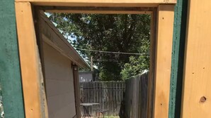 Un étroit sentier extérieur qui mène à une clôture en bois.