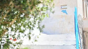 A set of white stone steps leading up to a building with a sign indicating the direction to Ikaria.