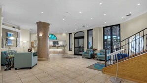 Eine geräumige Lobby mit Empfangstresen, Sitzgelegenheiten und einer Treppe.