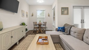 A living room with a sofa, a coffee table, a TV, a dining table with chairs, and a window with blinds. - 2 beach accesses in walking distance! ~1 bd/2ba on 30A~Sleeps 4! (Santa Rosa Beach)