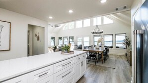 Una cocina amplia con una isla grande, electrodomésticos modernos y vistas al exterior.