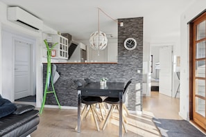 A modern kitchen with a dining table, a staircase, and a living area with a sofa. - Lovely holiday home near forest and beach (Aabenraa)