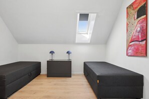 A room with two beds, a dresser, a skylight, and a painting. - Apartment with views close to the sea in Allinge (Allinge-Sandvig)