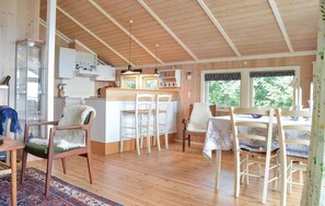 A cozy cabin interior with a kitchen, dining area, and seating.
