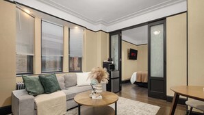 Un salon moderne avec un canapé, une table basse et un téléviseur fixé au mur.