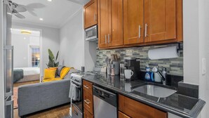 A compact kitchen with wooden cabinets, a microwave, a stove, and a dishwasher.