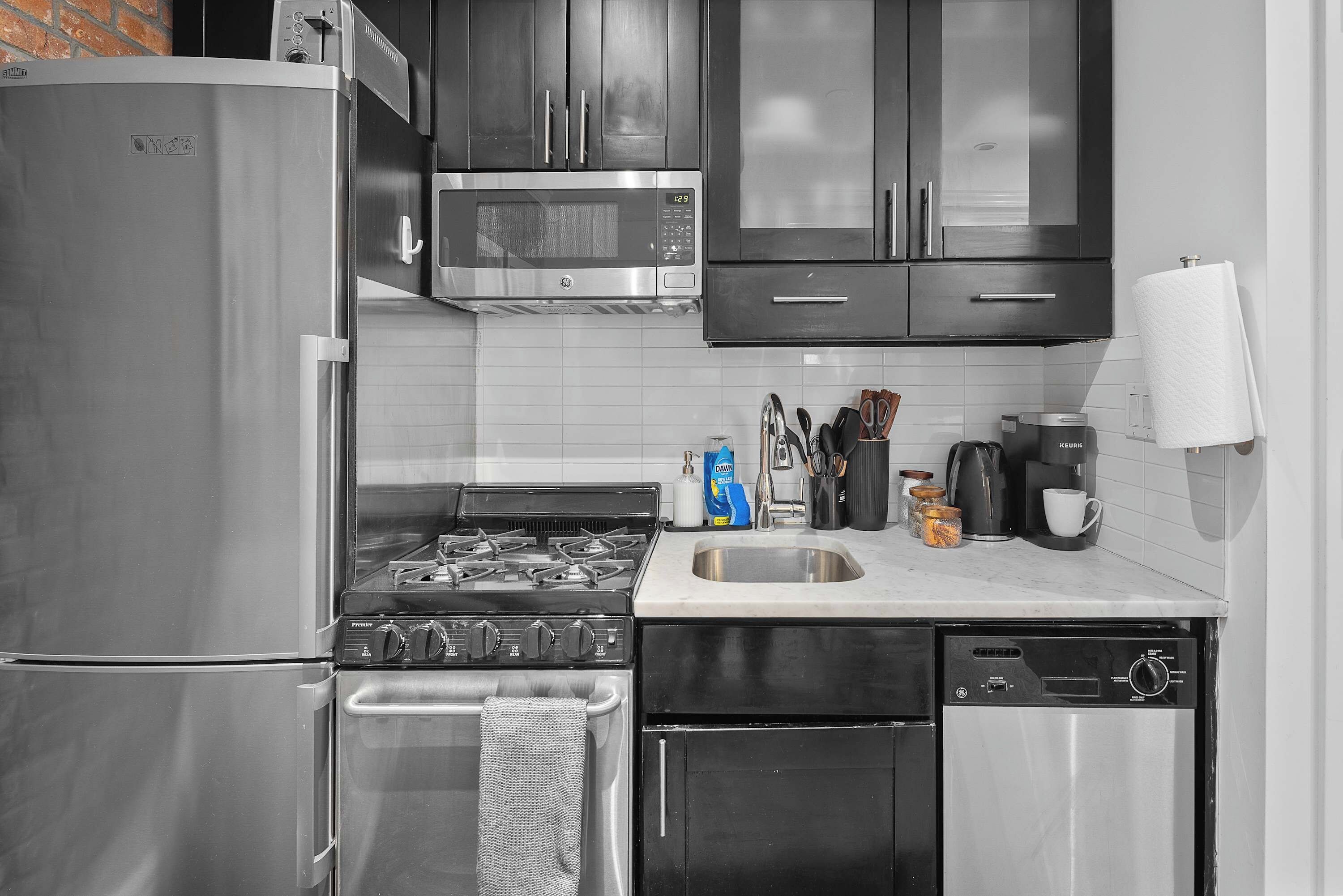 A kitchen with a stainless steel refrigerator, microwave, stove, and dishwasher.
