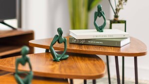 Une table en bois sur laquelle se trouve un livre intitulé « LIMITLESS YOU » et deux figurines vertes.