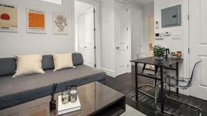 Ein modernes Wohnzimmer mit Sofa, Couchtisch und Essbereich.