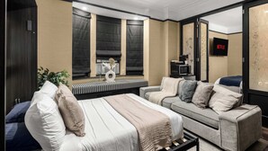 Une chambre d’hôtel moderne équipée d’un lit, d’un canapé, d’une télévision et d’une fenêtre avec des rideaux occultants.