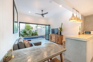 A modern living room with a pool, a TV, and a dining area. - Enclosed Airconditioned Living / 6 Minute Walk to Beach / Private Butler (Seminyak)