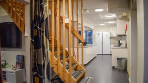 A modern kitchen with a wooden staircase leading to a second floor. - Beautiful home in Flyinge with WiFi (Flyinge)