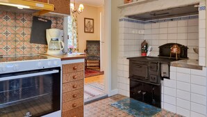 A kitchen with a stove, coffee maker, and a vintage oven. - 3 bedroom beautiful home in Broaryd (broaryd)