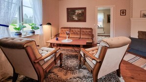 A cozy living room with a brown sofa, a wooden coffee table, and a patterned rug. - 3 bedroom beautiful home in Broaryd (broaryd)