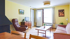 A living room with a sofa, armchair, and a TV on a wooden cabinet. - Amazing home in Ekshärad with WiFi (Ekshärad)
