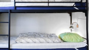 Un lit superposé avec un matelas simple et un oreiller sur le lit du bas.