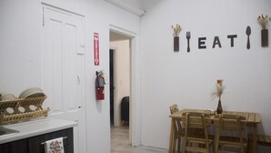 Una cucina con un tavolo da pranzo e sedie, un estintore e un cartello al muro che dice 'FIRE EATING'.