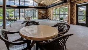 A spacious indoor area with a large table and chairs, large windows, and a view of the outside. - Beautiful 3-bedroom apt Skiview drive, 10 minutes to Gatlinburg (Gatlinburg)