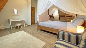 Una camera da letto con un letto a baldacchino, una scrivania e una sedia.