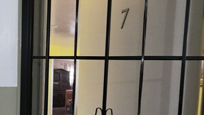 A close-up of a metal gate with a grid pattern and decorative swirls. - A cosy space Hollywood unit with walking distance to Sunset Blvd (Los Angeles)