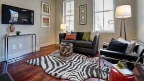 A living room with a sofa, a coffee table, a lamp, and a rug.