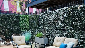 An outdoor seating area with a sofa, chairs, and a coffee table.