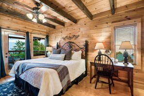 Une chambre dans une cabane en bois, avec un lit, un bureau et une chaise.