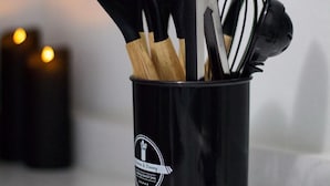 A black utensil holder with a label on it, containing various kitchen utensils. - Unit 1 Cozy Apartment with walking distance of bars, restaurant and beach (san juan)