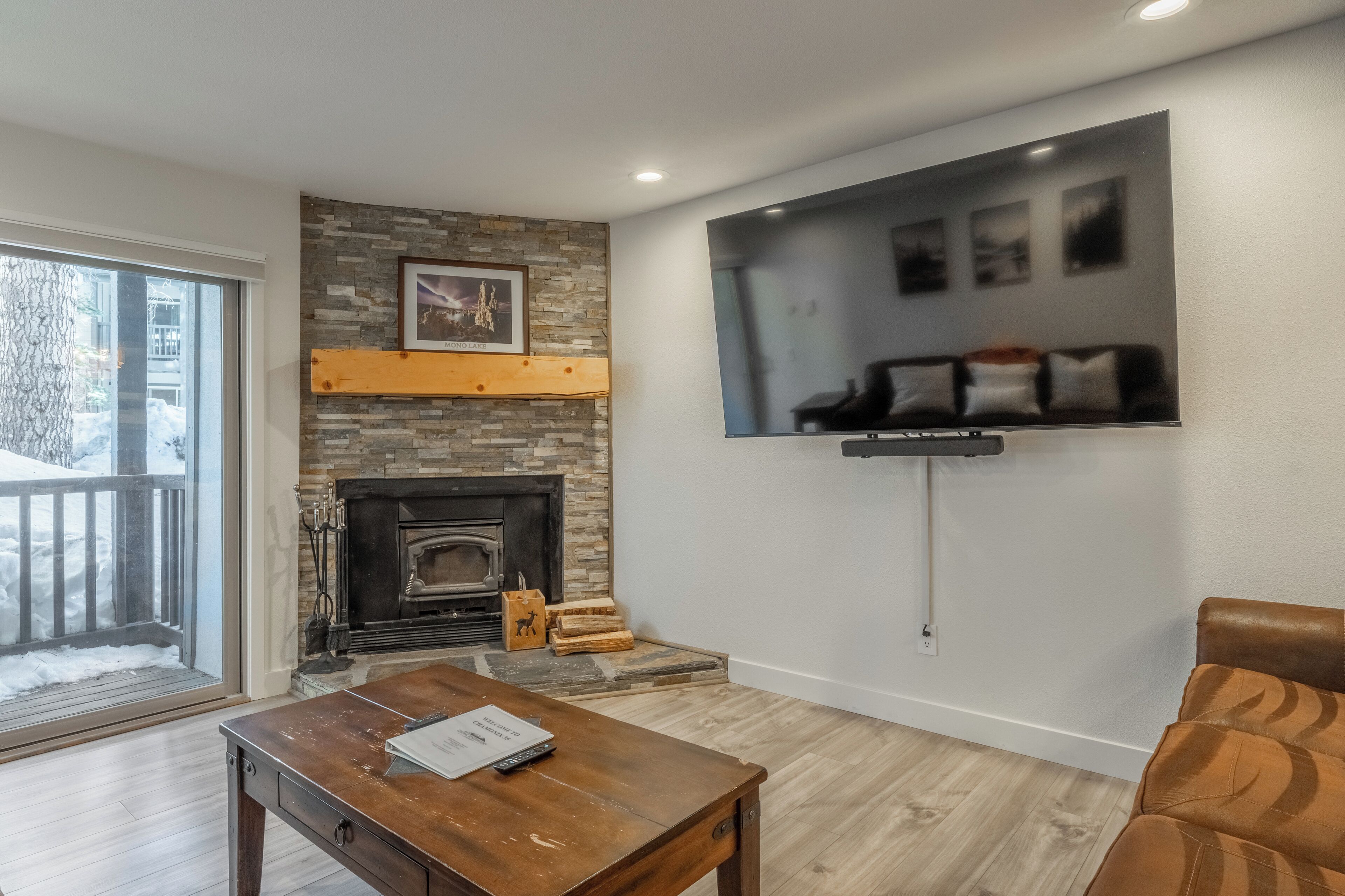 A living room with a fireplace, a mounted TV, and a wooden coffee table.
