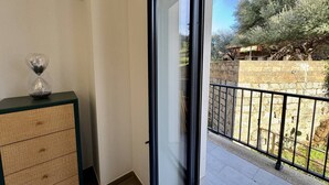 A balcony with a view of a garden and a stone wall. - Magnifique T3 tout confort (PROPRIANO)