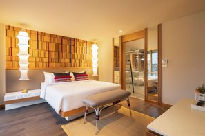 A modern hotel room with a large bed, bedside tables, a bench, and a glass shower enclosure. - Na U Hotel (Chiang Mai)