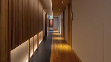 A long, narrow hallway with wooden paneling on one side and a carpeted floor.