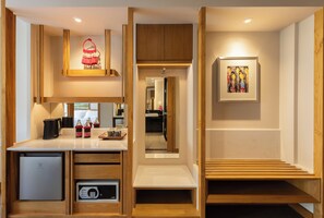 A compact kitchen with a coffee machine, a small refrigerator, and a microwave. - Na U Hotel (Chiang Mai)