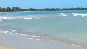A beach with clear turquoise water and a sandy shore. - Playas del Yunque - Beach Front - Rio Grande, PR (Rio Grande)