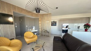 Un salon moderne avec un canapé en cuir marron, deux fauteuils jaunes et une table basse en verre.
