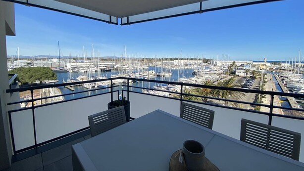 Un balcon avec vue sur une marina et des bateaux.